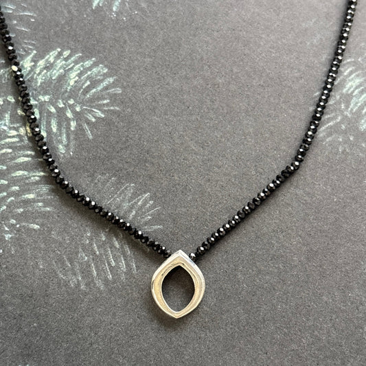 Necklace with a sterling silver clasp on a black spinel strand and Bud pendant