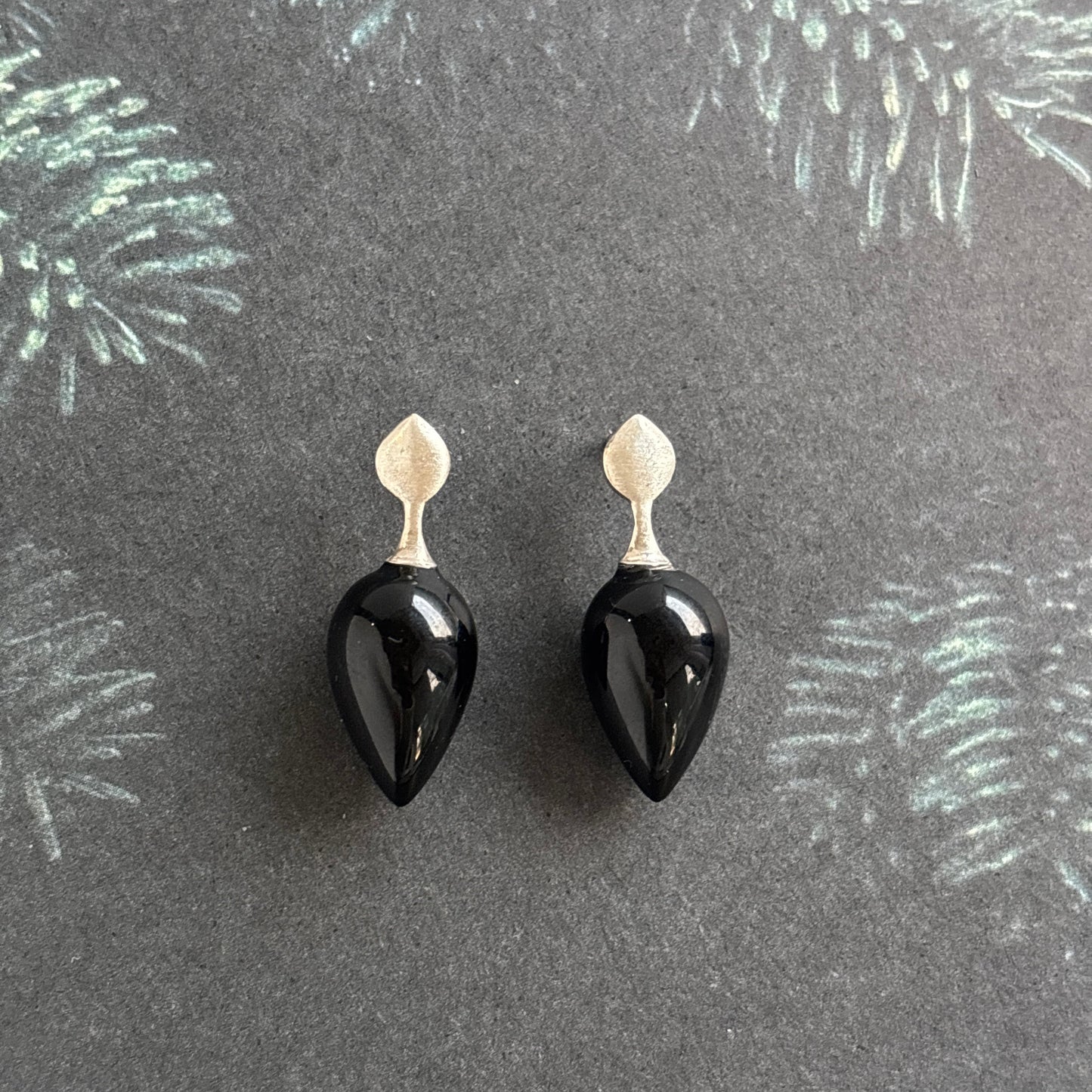 Black teardrop-shaped onyx earrings on sterling silver empress tops