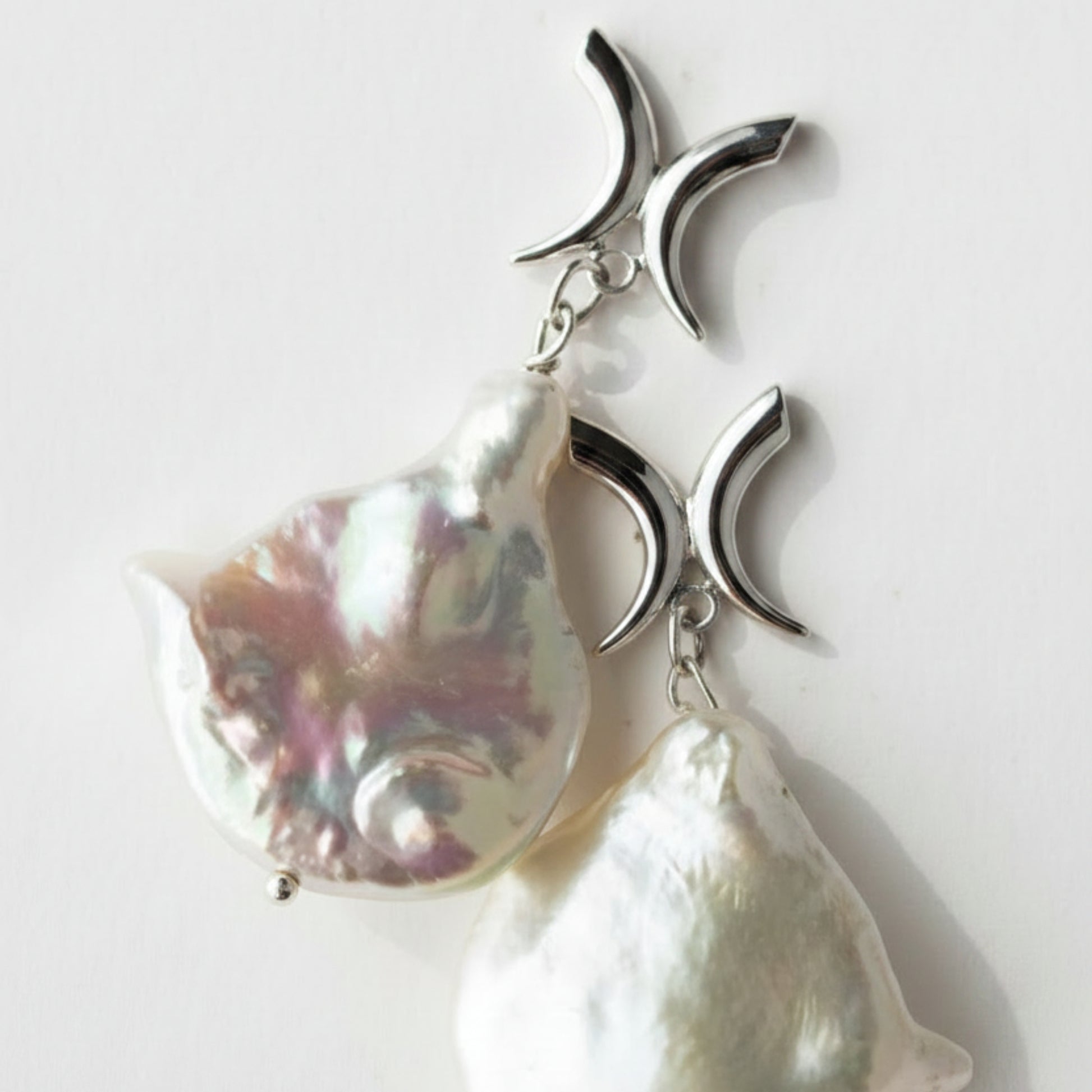 A pair of baroque pearl earrings with sterling silver X shape studs 